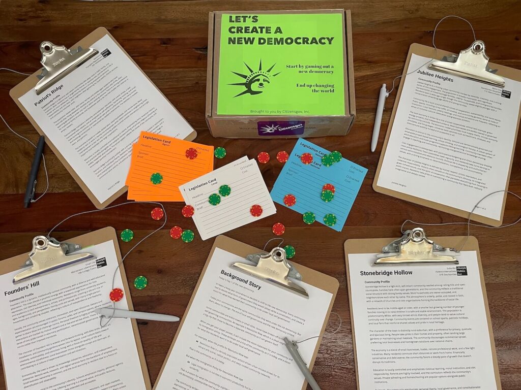 Photo of components for gaming out a new democracy. Includes several community profiles, the background story, and legislation cards.